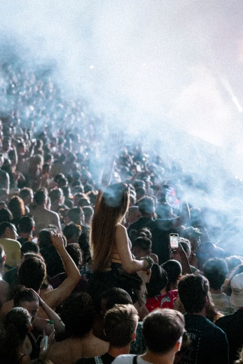 Stadium crowd under white haze with attendee on shoulders