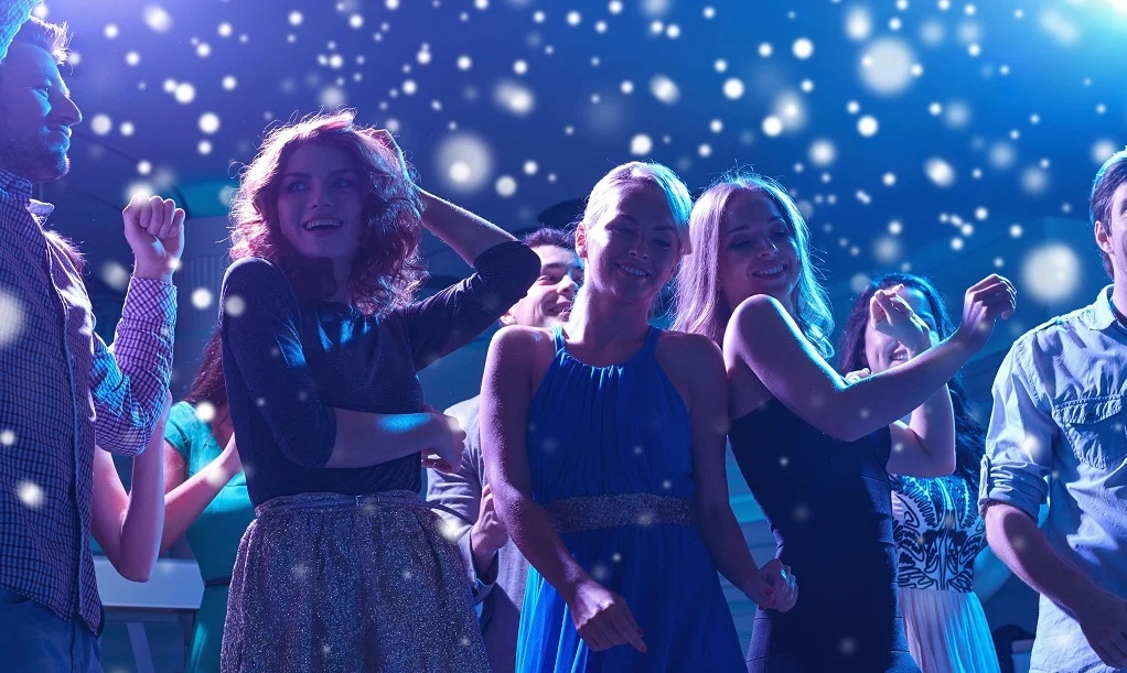 Friends dancing together at live event under concert lights